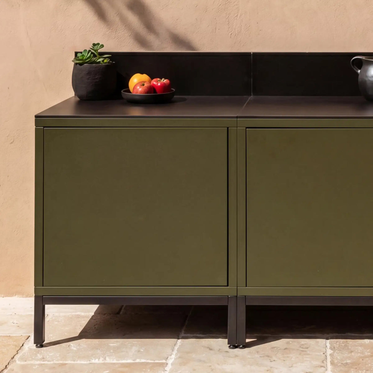 Cucina da esterno Pilotis verde oliva con piano di lavoro classico in ceramica nera.
::visuel:noir