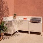 Cucina da esterno ad angolo Pilotis bianco crema con piano di lavoro classico in ceramica bianca e plancha Vivaplancha.
::visuel:creme