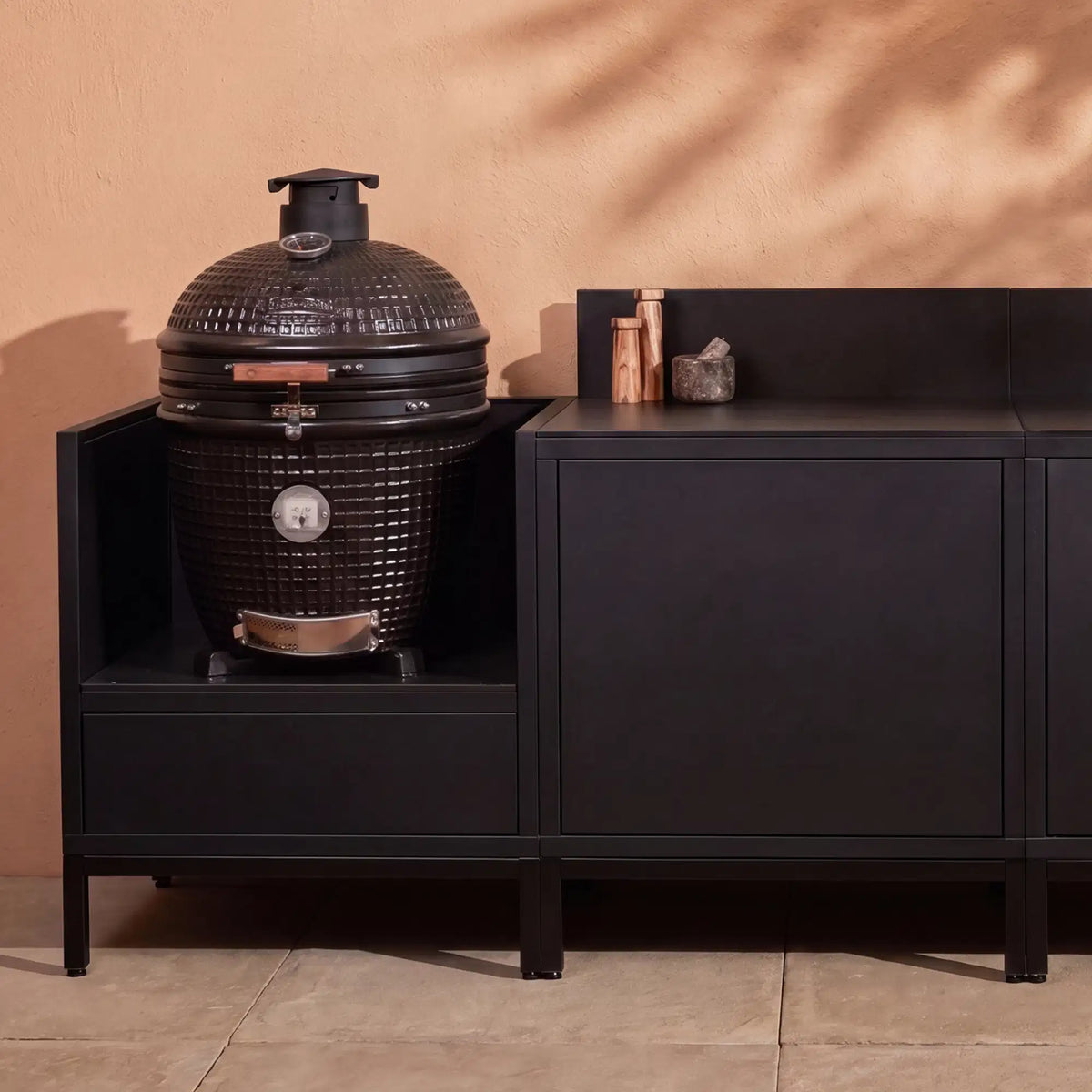 Cucina da esterno Pilotis nero profondo con modulo kamado e piano di lavoro in ceramica nera.
::visuel:noir