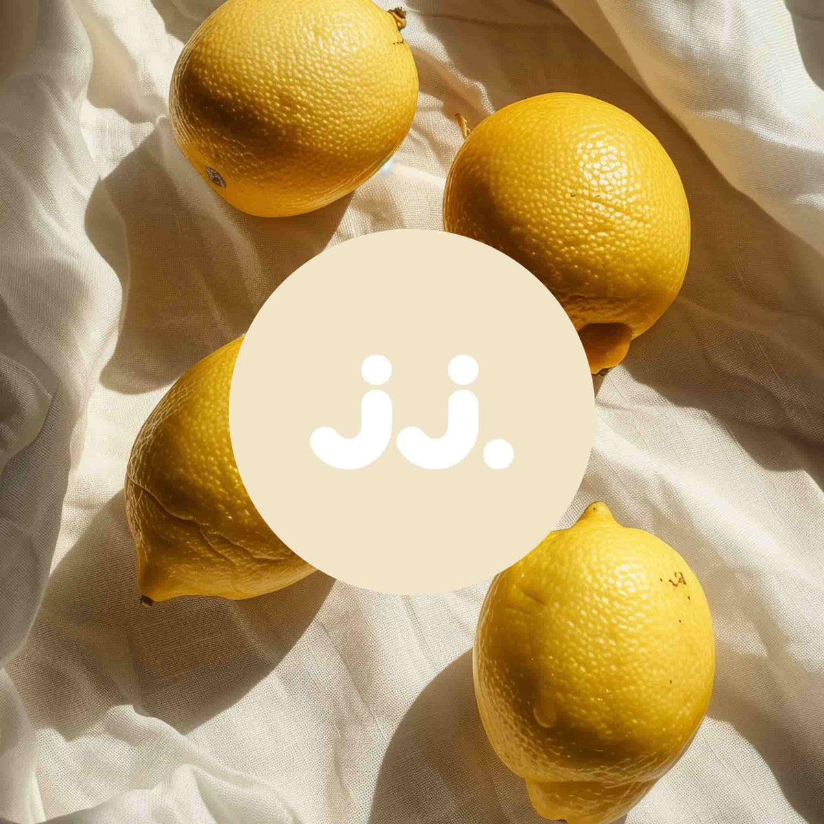 Citron jaune sur tissu clair avec logo jj., évoquant la senteur Citronnelle & Citron. 