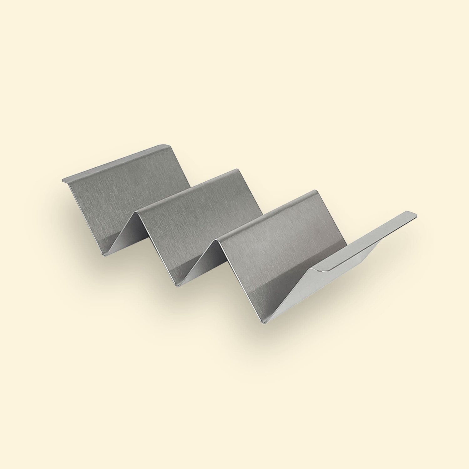 Support de maintien au chaud en inox, en forme de structure ondulée à trois niveaux, destiné à garder les aliments surélevés sur la plancha.