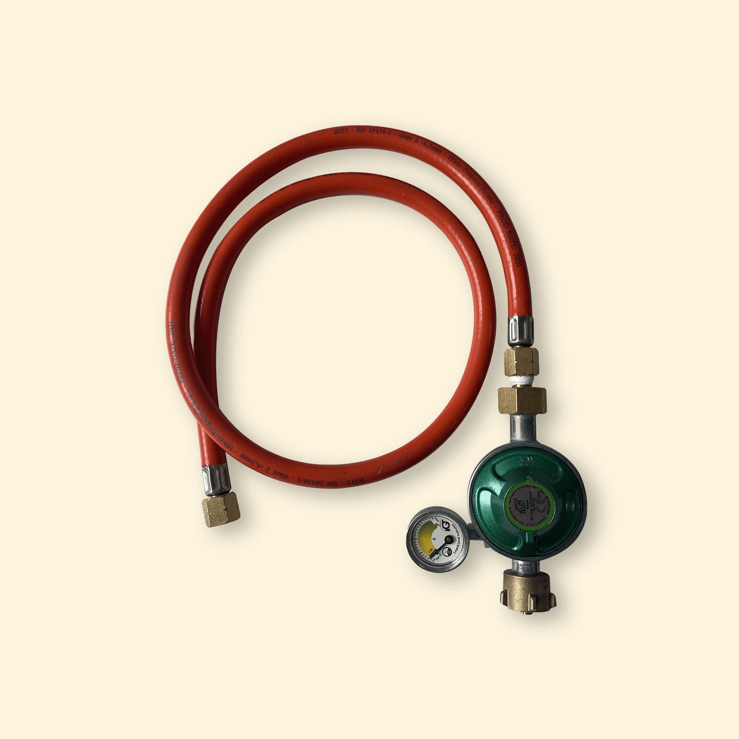 Tuyau de gaz rouge avec détendeur vert équipé d’un manomètre, compatible installation gaz Allemagne/Autriche, présenté sur fond uni clair.