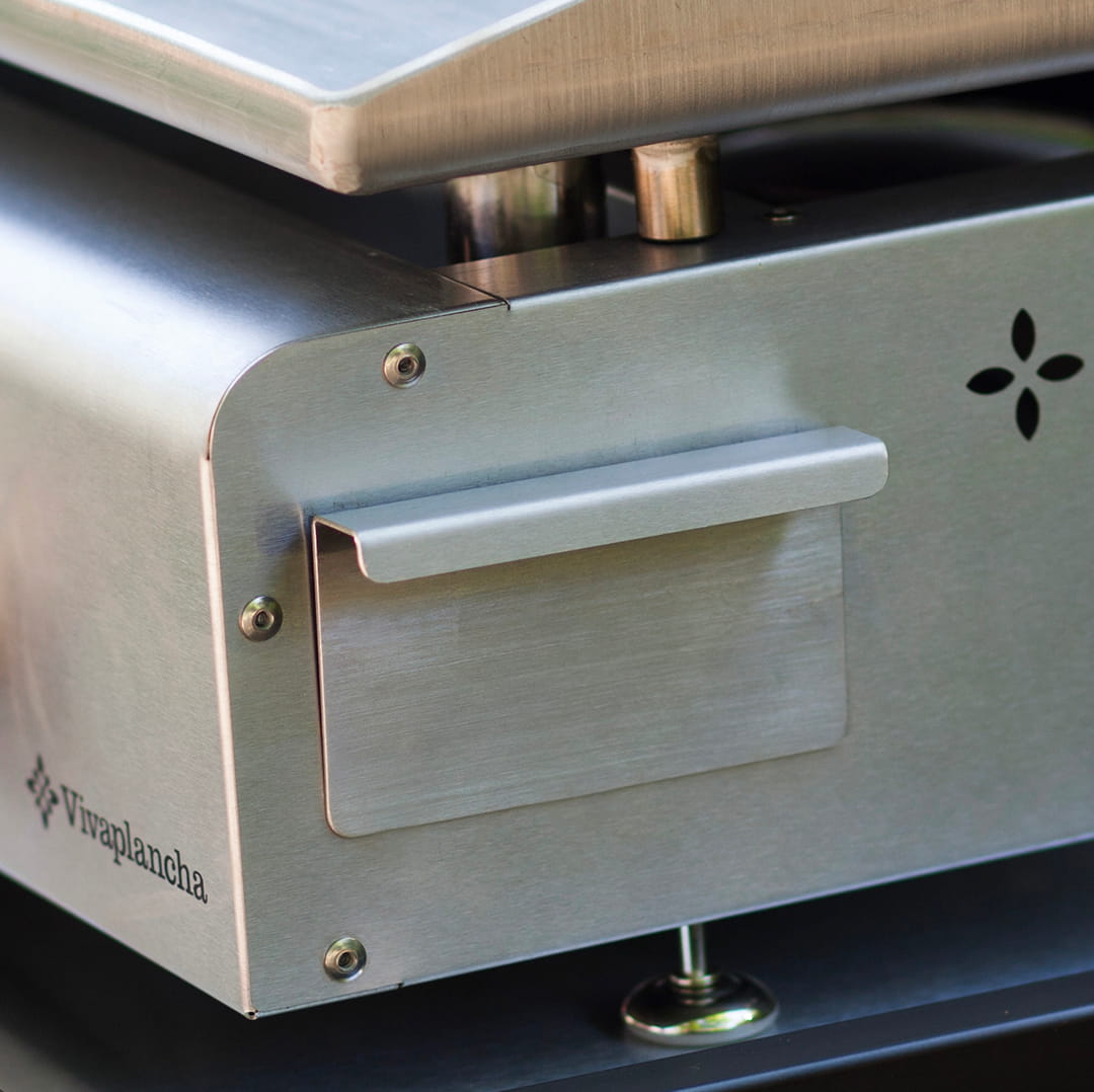 Vue rapprochée du récupérateur de graisses en inox d’une plancha Vivaplancha, intégré sur le côté de l’appareil.